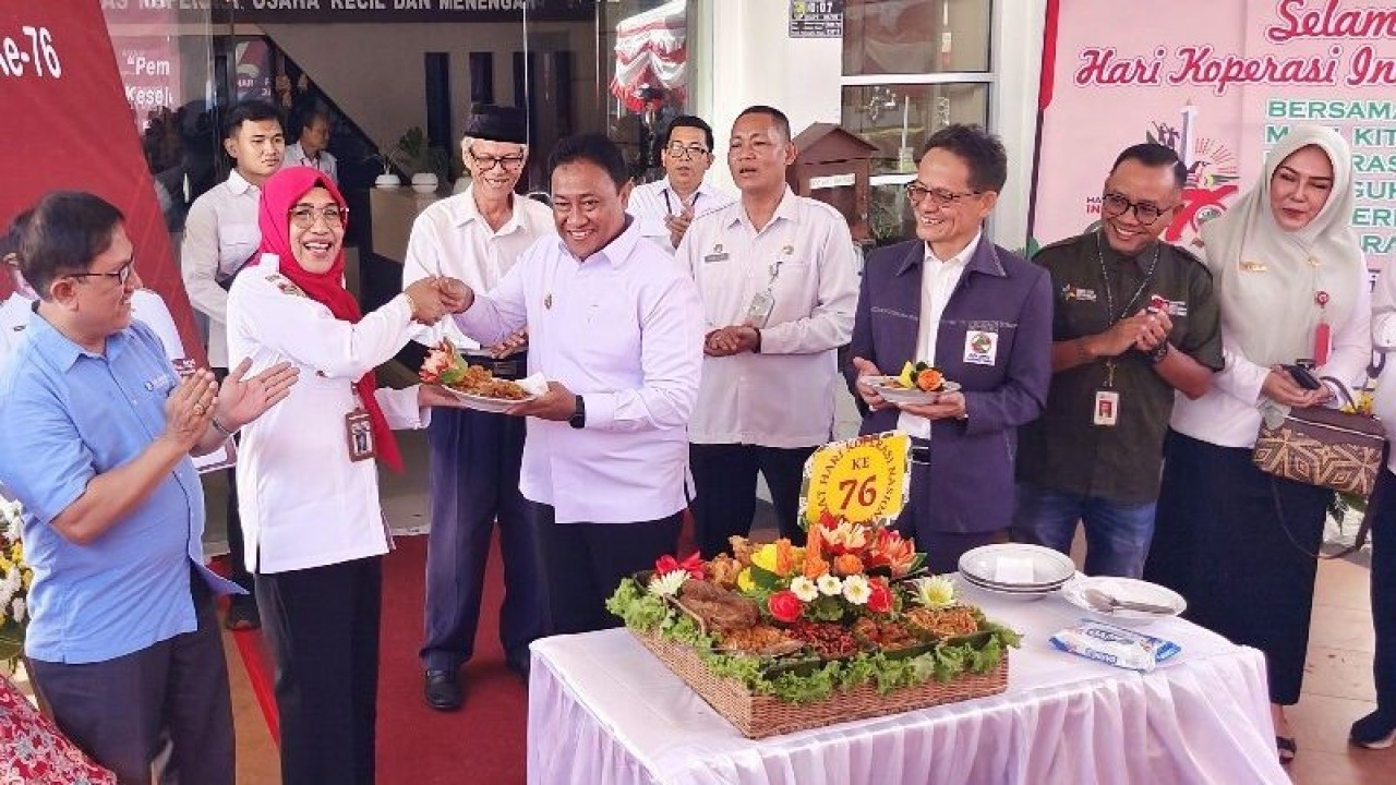 Wagub Kalteng Edy Pratowo menyerahkan potongan kue tumpeng kepada Kepala Dinas Koperasi dan UKM Kalteng Norhani di sela Peringatan Hari Koperasi ke-76, di Palangka Raya, Rabu (12/7/2023). ANTARA/Muhammad Arif Hidayat.
