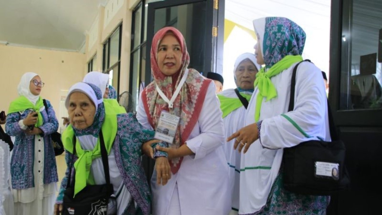 Petugas membantu calon jamaah haji di Embarkasi Haji Padang sebelum bertolak ke Tanah Suci Mekkah. (ANTARA/HO-Humas Kemenag Sumbar).