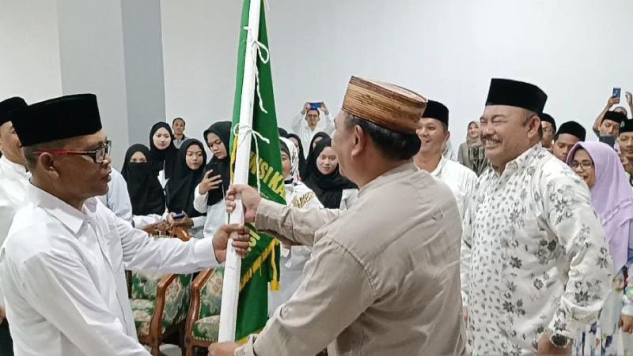 Kakanwil Kemenag Muhajirin Yanis menyerahkan bendera Kemenag Kalbar kepada Mahdi Siregar sebagai Ketua Kafilah yang akan mengikuti MQKN di Lamongan, 10-19 Juli 2023. ANTARA/Dedi