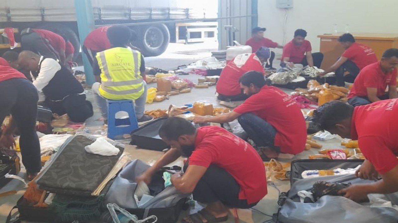 Petugas membongkar koper untuk mengeluarkan air zamzam yang dimasukkan ke dalam bagasi anggota jamaah haji menjelang pemulangan jamaah haji ke Indonesia. (ANTARA/HO-Kemenag)