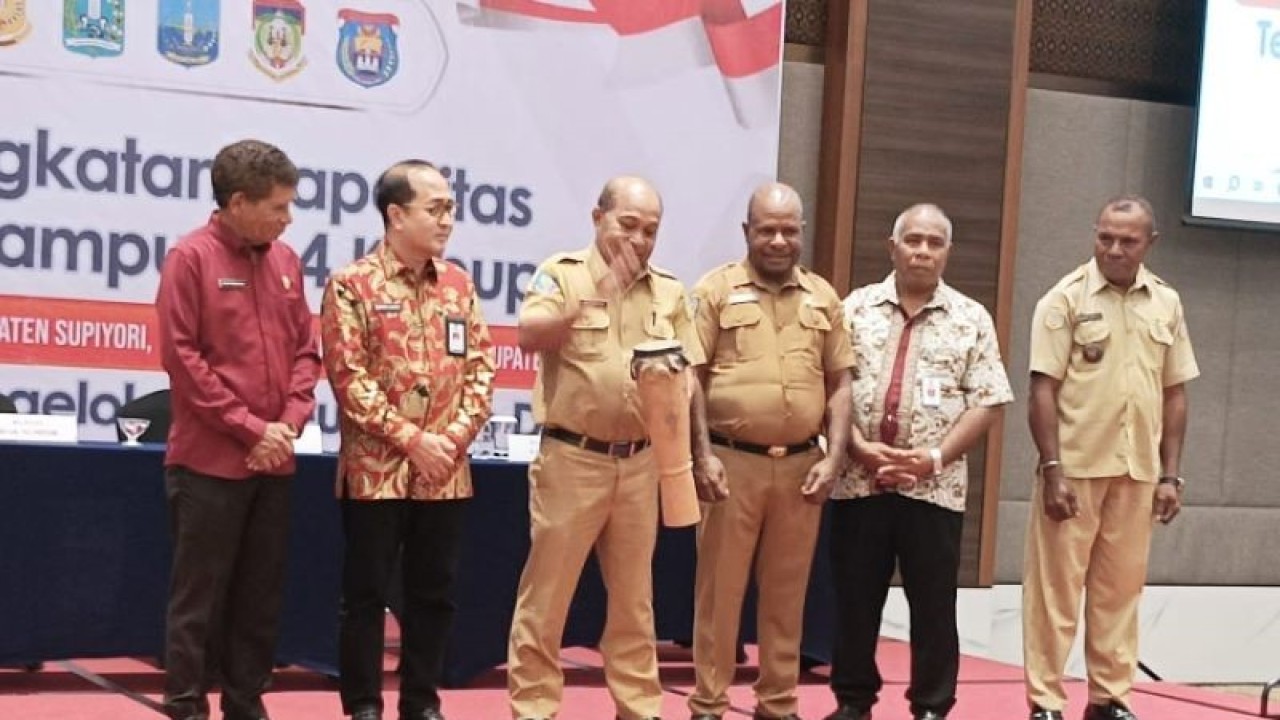 Penjabat Fungsional Analis Madya Pemprov Papua Yan Piet Rawar didampingi Direktur Pembangunan Ekonomi Kawasan pedesaan Kemendes PDT Lutfi Latif dan Wabup Biak Calvin Mansnembra (baju merah) membuka pelatihan penguatan kapasitas tata kelola keuangan aparat kampung seluruh Saereri. (ANTARA/Muhsidin)