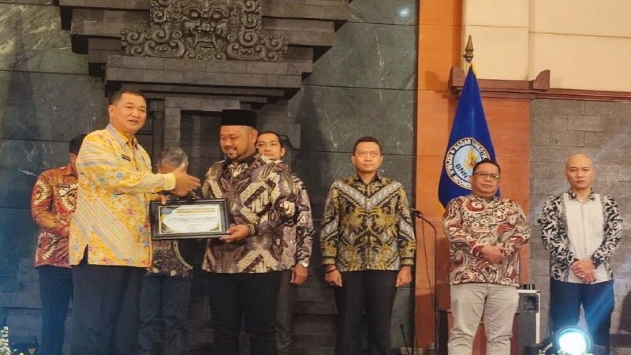Kepala BNNP Jatim Brigjen Pol. M. Aris Purnomo memberikan penghargaan kepada Bupati Gresik Fandi Ahmad Yani di saat peringatan Hari Anti-Narkotika Internasional (HANI) 2023 di Surabaya, Kamis (27/7/2023). (ANTARA/Willi Irawan)