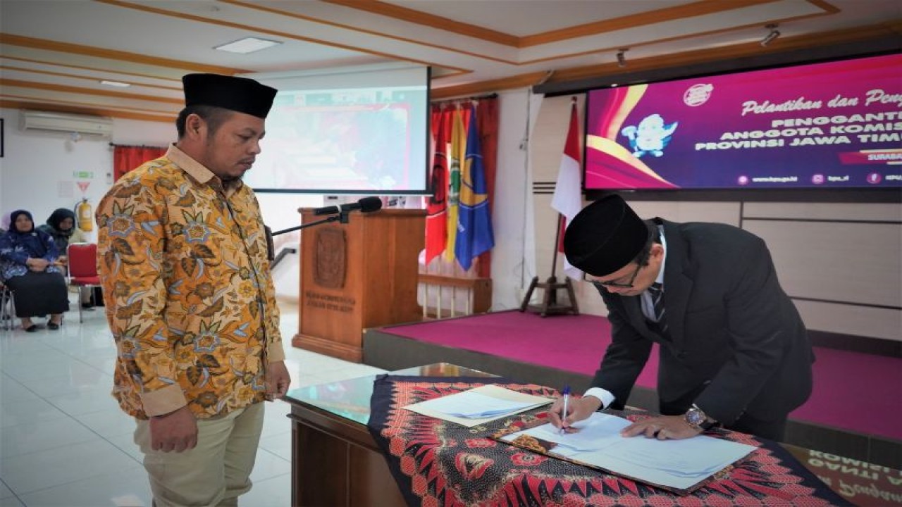 Athoilla (kanan) menandatangani dokumen di sela pelantikan sebagai komisioner KPU Jatim dan disaksikan Ketua KPU Jatim Choirul Anam di Surabaya, Rabu (26/7/2023). (ANTARA/HO-KPU Jatim)