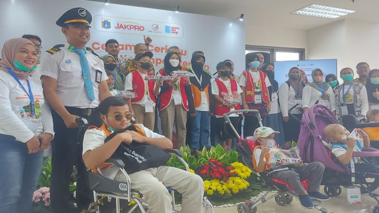 Sejumlah anak berkursi roda berfoto bersama masinis dan pegawai LRT Jakarta di Pegangsaan Dua, Kelapa Gading, Jakarta Utara, Senin (24/7/2023). ANTARA/Abdu Faisal