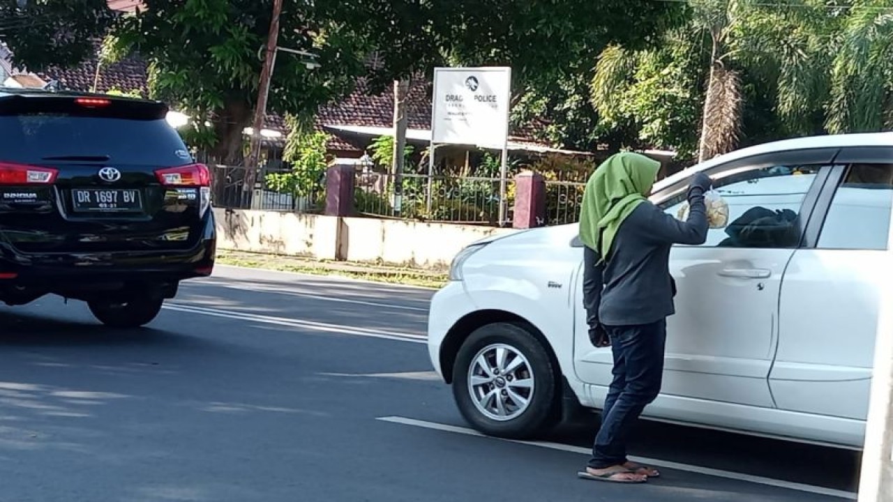 Arsip Foto - Seorang pedagang asongan menjajakan dagangan kepada pengendara di jalan raya di dekat lampu lalu lintas simpang Sweta, Kota Mataram, Provinsi Nusa Tenggara Barat. (ANTARA/Nirkomala)