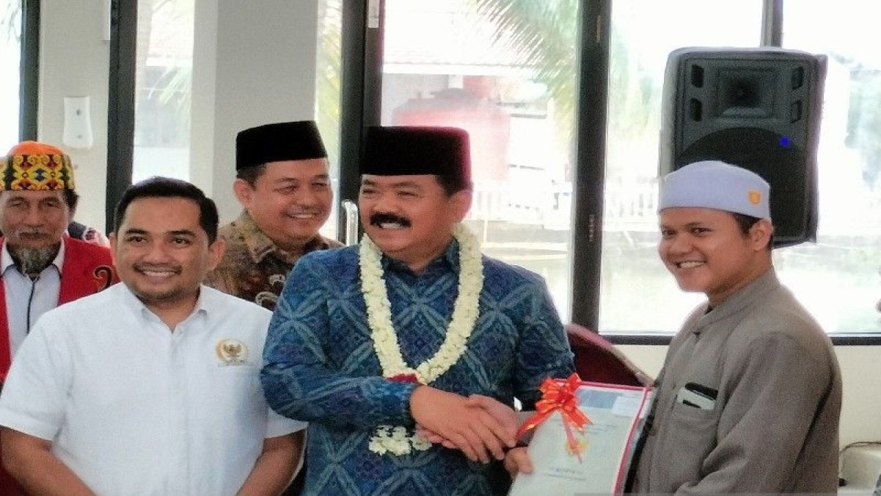 Menteri Agraria dan Tata Ruang/Kepala Badan Pertanahan Nasional Hadi Tjahjanto (tengah) menyerahkan secara simbolik sertifikat tanah wakaf untuk pondok pesantren, masjid dan mushola di Kota Banjarbaru, Kalimantan Selatan, Kamis (13/7/2023). ANTARA/Aji Cakti