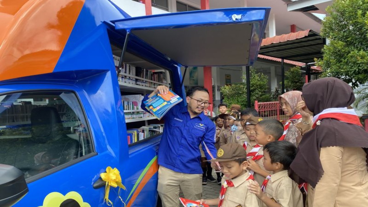 Siswa sekolah di Batam, Kepri, mengantre untuk meminjam buku di mobil layanan perpustakaan keliling (FOTO ANTARA/Jessica)