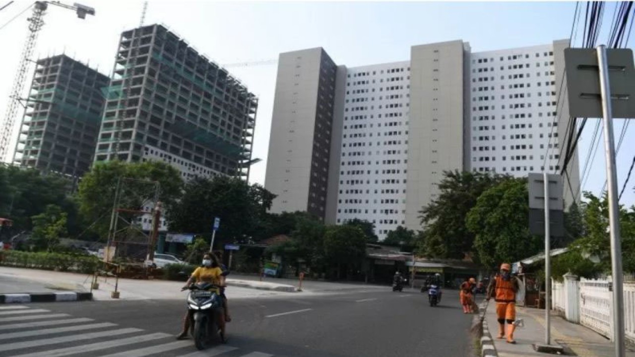 Pengendara sepeda motor melaju di depan bangunan rumah susun sederhana milik (Rusunami) Klapa Village yang merupakan hunian dengan program DP (uang muka) Rp0 di Pondok Kelapa, Jakarta, Kamis (18/3/2021). ANTARA FOTO/Hafidz Mubarak A/aww.