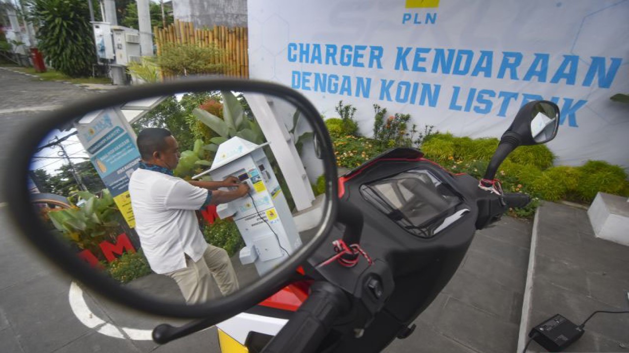 Arsip foto - Seorang pria mengisi daya baterai sepeda motor listriknya di SPKLU Charger kendaraan dengan koin listrik (Cak Kolis) di Mataram, NTB, Senin (5/12/2022). (ANTARA FOTO/Ahmad Subaidi/tom)