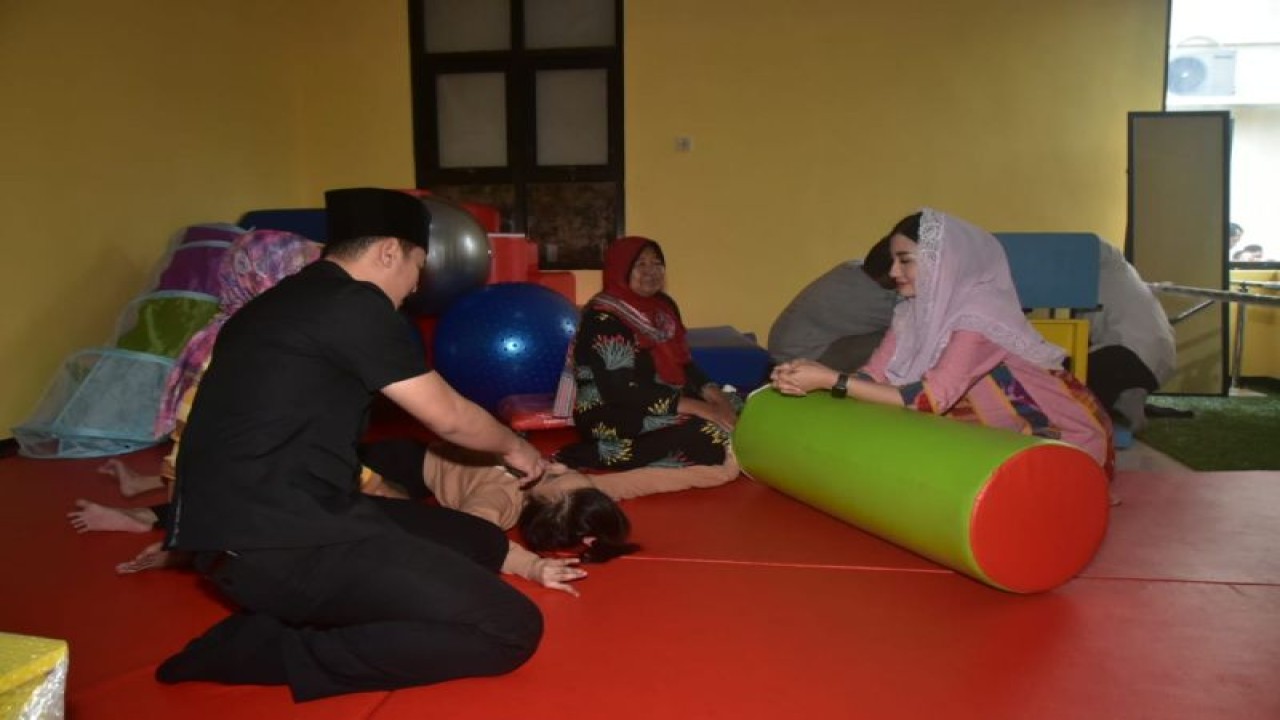 Bupati Trenggalek Mochamad Nur Arifin (kiri) dan istri yang juga etua tim penggerak PKK Trenggalek Novita Hardini (kanan) bermain dengan anak disabilitas di rumah layanan anak berkebutuhan khusus yang barusan diresmikan, di Trenggalek, Rabu (26/7/2023) (ANTARA/HO - Prokopim Trenggalek)