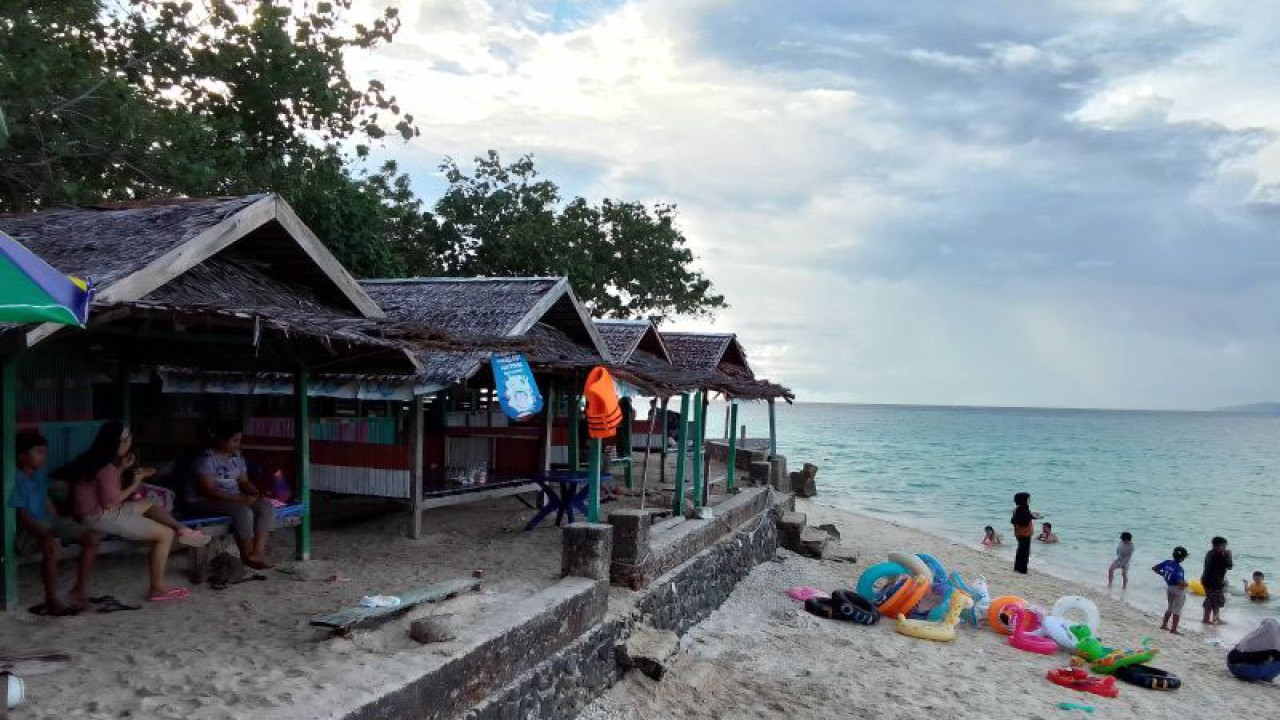Pengunjung menikmati waktu bersama keluarga di gazebo yang berada di tepi Pantai Tanjung Karang, Desa Labuan Bajo, Kabupaten Donggala, Sulawesi Tengah, Minggu (2/7/2023). (ANTARA/Nur Amalia Amir)