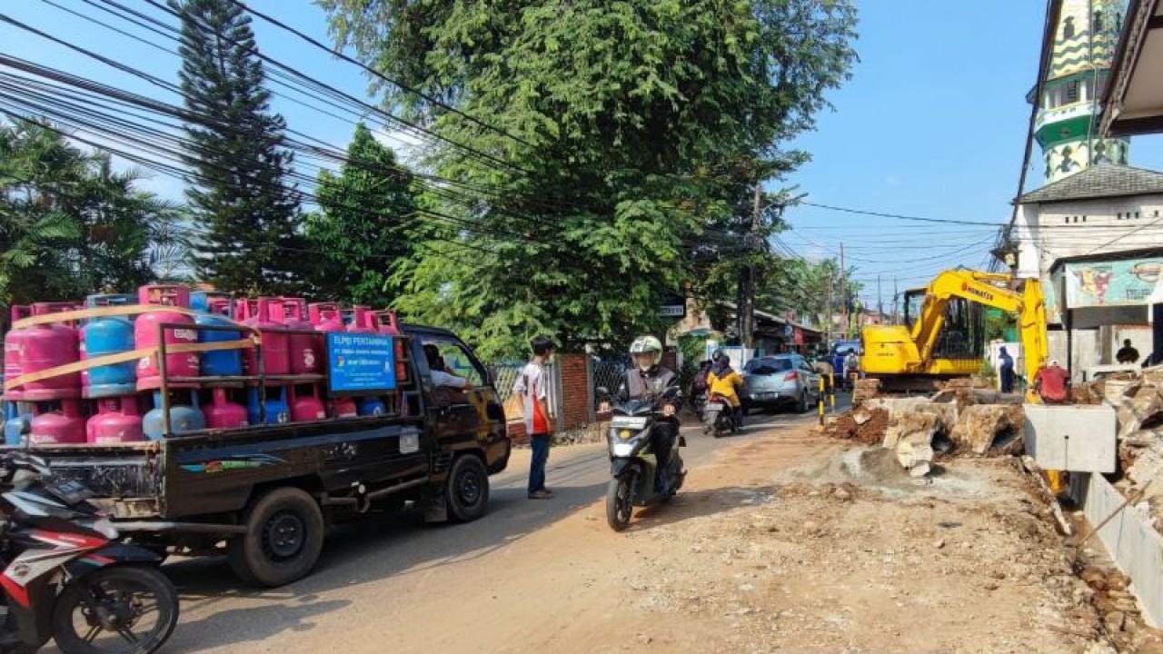 Dua orang pekerja tengah memperbaiki saluran air di Jalan Robusta Raya, Kelurahan Pondok Kopi, Kecamatan Duren Sawit, Jakarta Timur, Senin (17/7/2023). Pengerjaan perbaikan saluran air menyebabkan arus lalu lintas di kawasan itu tersendat. ANTARA/Syaiful Hakim