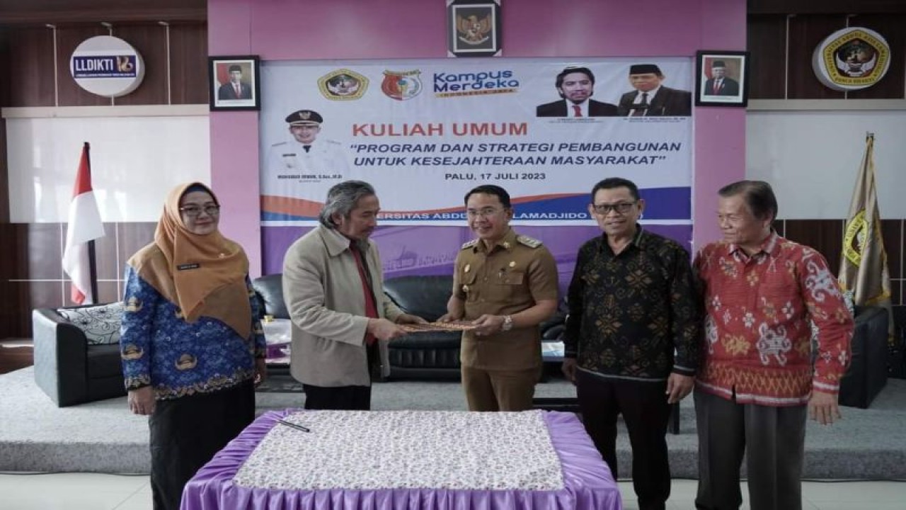 Bupati Sigi Mohamad Irwan dan Rendy Lamadjido dari pihak Universitas Azlam foto bersama sambil memegang naskah MoU yang ditandatangani dua pihak tersebut. (ANTARA/HO-Dok Prokopim Setda Pemkab Sigi)