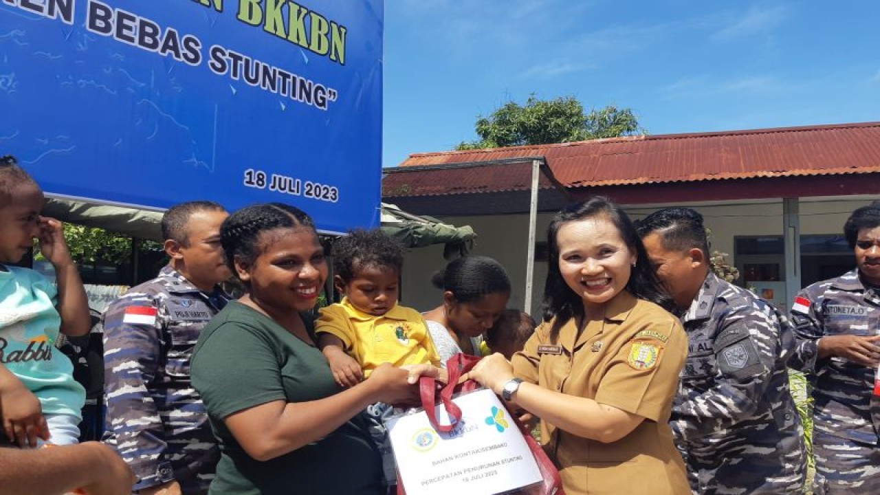 Asisten II Bidang Pembangunan Setda Kota Jayapura Widhi Hartanti (kanan) saat menyerahkan paket sembako kepada warga saat kegiatan kolaborasi Lantamal X Jayapura bersama BKKBN Papua dalam percepatan penurunan stunting di Kota Jayapura, Selasa (18/7/2023) (FOTO ANTARA/Ardiles Leloltery)
