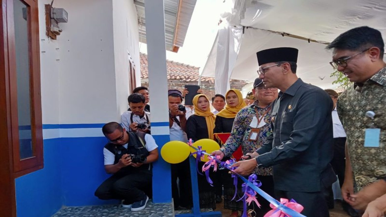 Wali Kota Mataram H Mohan Roliskana (tengah pakai peci) memotong pita sebagai rangkaian dari serah terima pembangunan rumah layak huni di Kelurahan Kebon Sari Ampenan, Kota Mataram, Provinsi Nusa Tenggara Barat. Rabu (12/7-2023). (ANTARA/Nirkomala)