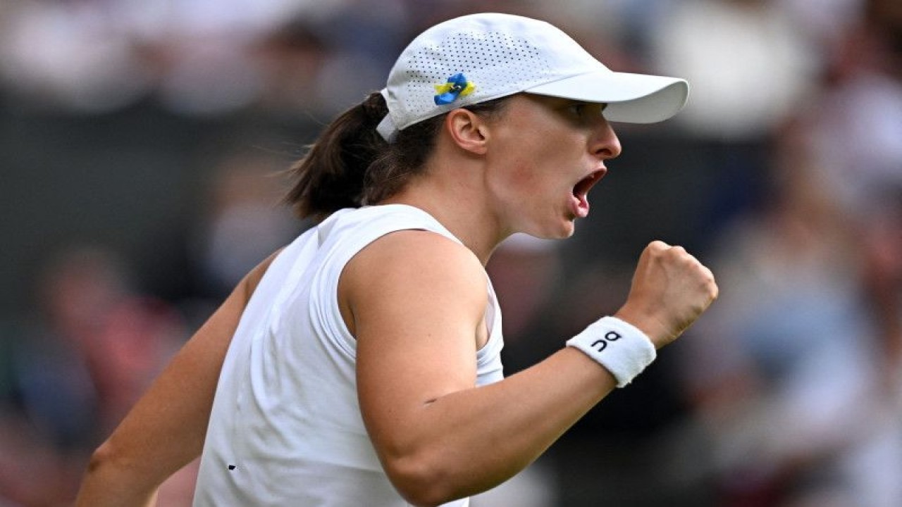 Petenis Polandia Iga Swiatek bereaksi selama pertandingan babak keempat Wimbledon melawan petenis Swiss Belinda Bencic di All England Lawn Tennis and Croquet Club, London, Inggris, Minggu (9/7/2023). (ANTARA/REUTERS/Dylan Martinez)