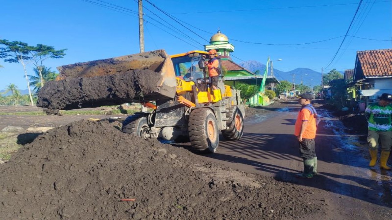 Petugas membersihkan lumpur sisa banjir lahar dingin Gunung Semeru di jalan Desa Nguter, Kecamatan Pasirian, Kabupaten Lumajang, Provinsi Jawa Timur, Selasa (11/7/2023). (ANTARA/HO-BPBD Lumajang)