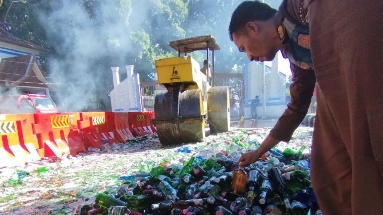 Petugas memusnahkan minuman keras di halaman Pendopo, Kabupaten Garut, Jawa Barat, Rabu (12/7/2023). (ANTARA/Feri Purnama)