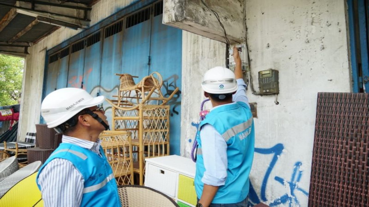 Pekerja PLN saat melakukan penggantian kWh meter lama dengan Smart Meter AMI di salah satu rumah warga Sidoarjo, Jawa Timur. (ANTARA/HO-Humas PLN)