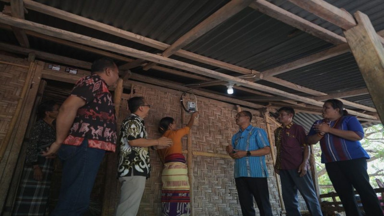 Bupati Sumba Tengah Paulus Limu (ketiga kanan) bersama pihak PT PLN Unit Induk Wilayah NTT menyaksikan warga menyalahkan meteran listrik yang tersambung jaringan listrik melalui pembangunan listrik desa. (ANTARA/HO-Humas PLN UIW NTT