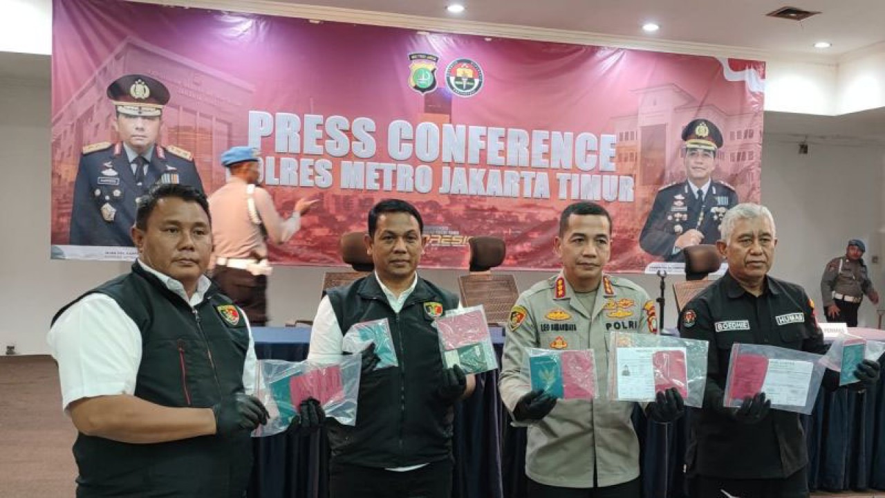 Kapolres Metro Jakarta Timur Kombes Pol Leonardus Simarmata (kedua kanan) saat memperlihatkan barang bukti paspor yang digunakan pelaku untuk menjadi pekerja migran Indonesia (PMI) ilegal di Mapolres Metro Jaktim, Jatinegara, Selasa (18/7/2023). ANTARA/Syaiful Hakim