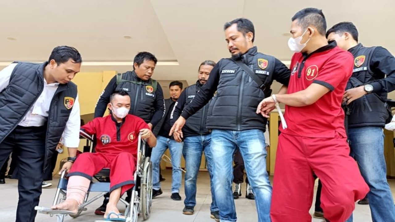 Petugas kepolisian mengawal kedua pelaku pencurian asal Sumatera Selatan yang melancarkan aksi dengan modus memecahkan kaca mobil korban usai mengikuti konferensi pers di Polda NTB, Mataram, Senin (24/7/2023). ANTARA/Dhimas BP