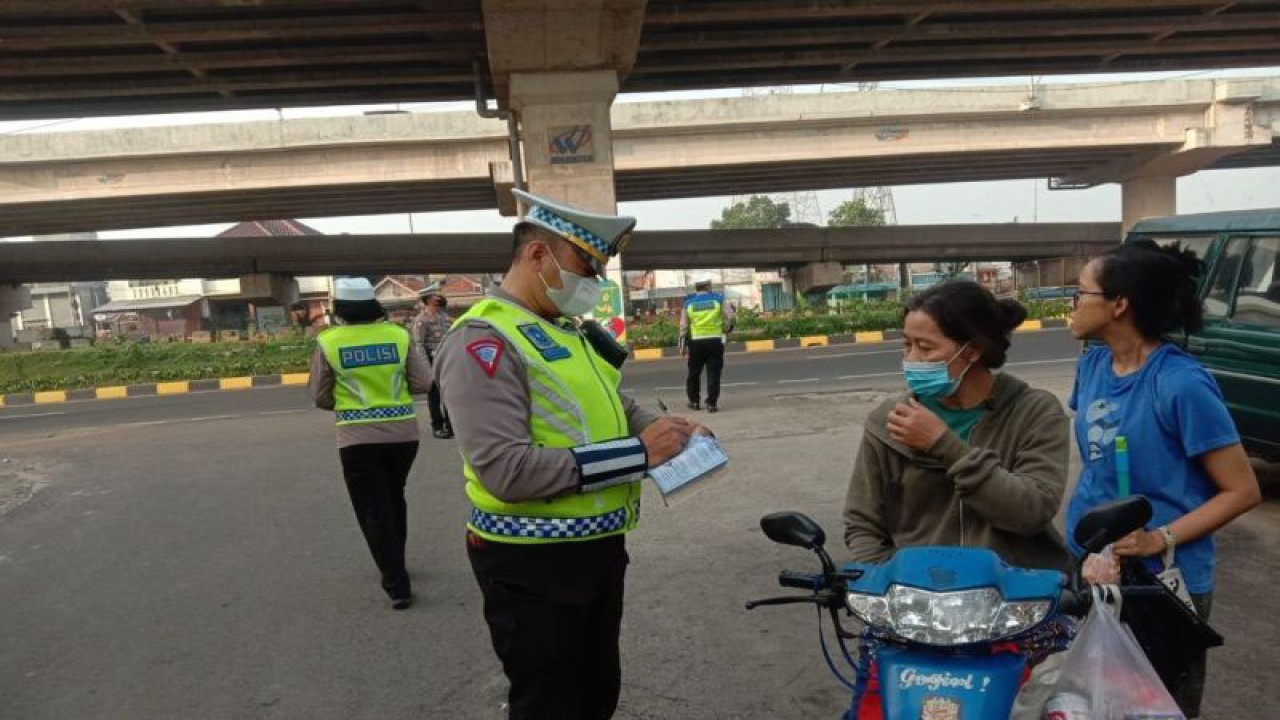 Seorang anggota Ditlantas Polda Metro Jaya melakukan penindakan terhadap pengguna kendaraan bermotor roda dua yang tidak menggunakan helm di Jalan Kalimalang, Duren Sawit, Jakarta Timur, Rabu (12/7/2023). ANTARA/HO-Ditlantas Polda Metro Jaya