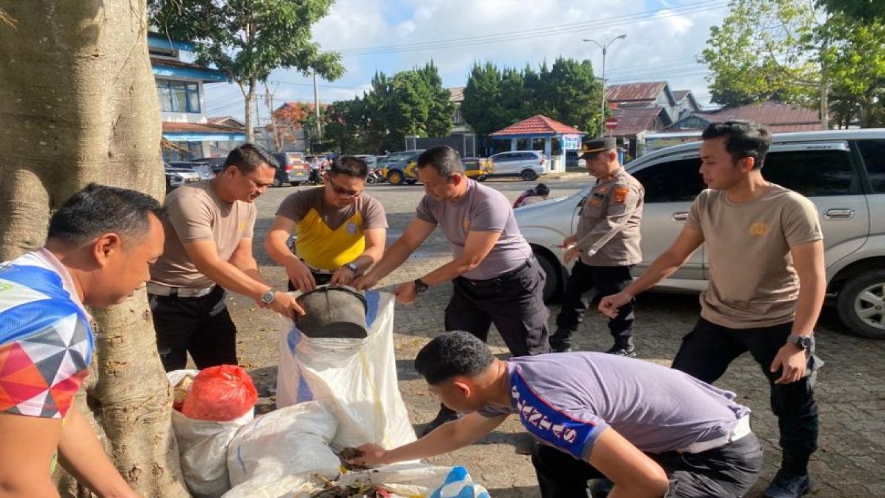 Suasana saat personil polisi dan masyarakat membersihkan sampah di pasar Liwa Lampung Barat. ANTARA/HO