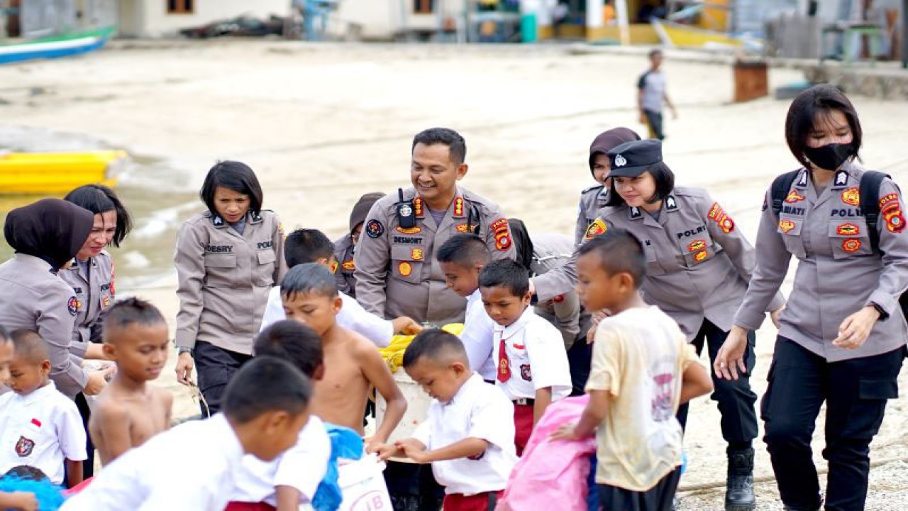Sejumlah bocah bersama anggota Polisi mengangkat sampah plastik dan karung bekas di tepi pantai Desa Modelomo, Kabupaten Bone Bolango, Gorontalo, Kamis (13/7/2023). ANTARA/Adiwinata Solihin