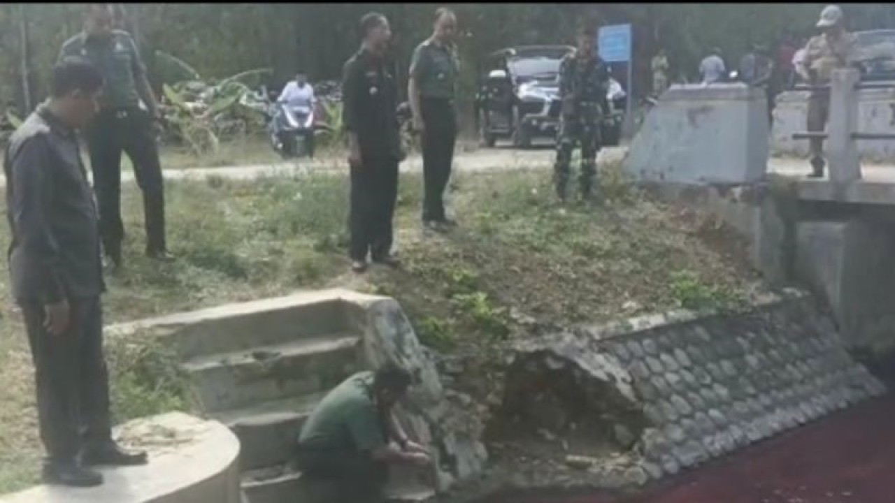 Komandan Kodim 0826 Pamekasan Letkol Ubaidillah memeriksa langsung air sungai berwarna merah yang tercemar limbah batik di Waduk Desa Klampar, Pamekasan. (ANTARA/HO-Kodim Pamekasan)