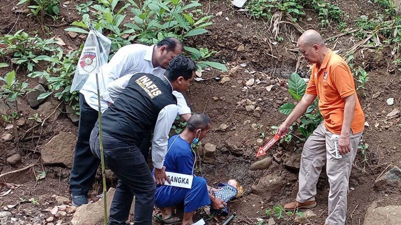 Tersangka R memeragakan adegan mengubur bayi hasil hubungan sedarah dengan anaknya dalam rekonstruksi yang digelar Satreskrim Polresta Banyumas di lahan tepi Sungai Banjaran, Kelurahan Tanjung RT 01 RW 02, Kecamatan Purwokerto Selatan, Kabupaten Banyumas, Senin (24/7/2023). ANTARA/Sumarwoto