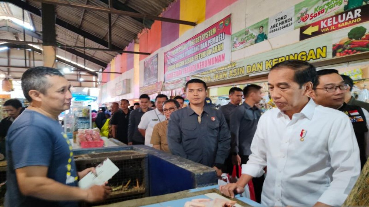 Presiden Joko Widodo (Jokowi) berbincang dengan pedagang mengenai harga pangan dan menyerahkan bantuan kepada para pedagang di Pasar Cihapit, Kota Bandung, Jawa Barat, Rabu (12/7/2023). ANTARA/Ricky Prayoga
