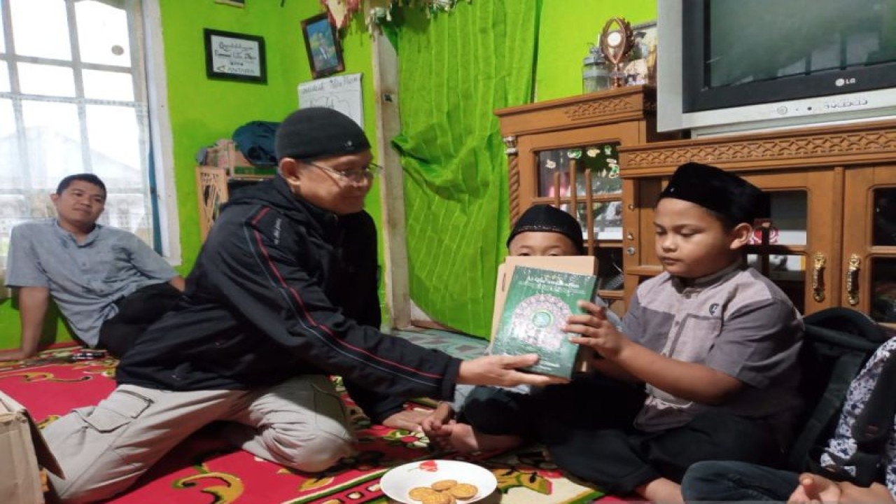 PT Sinai cabang Diponegoro Padang membagikan mushaf Quran ke salah seorang murid di rumah Quran Al Fattah Solok, Sumbar (ANTARA/Laila Syafarud)