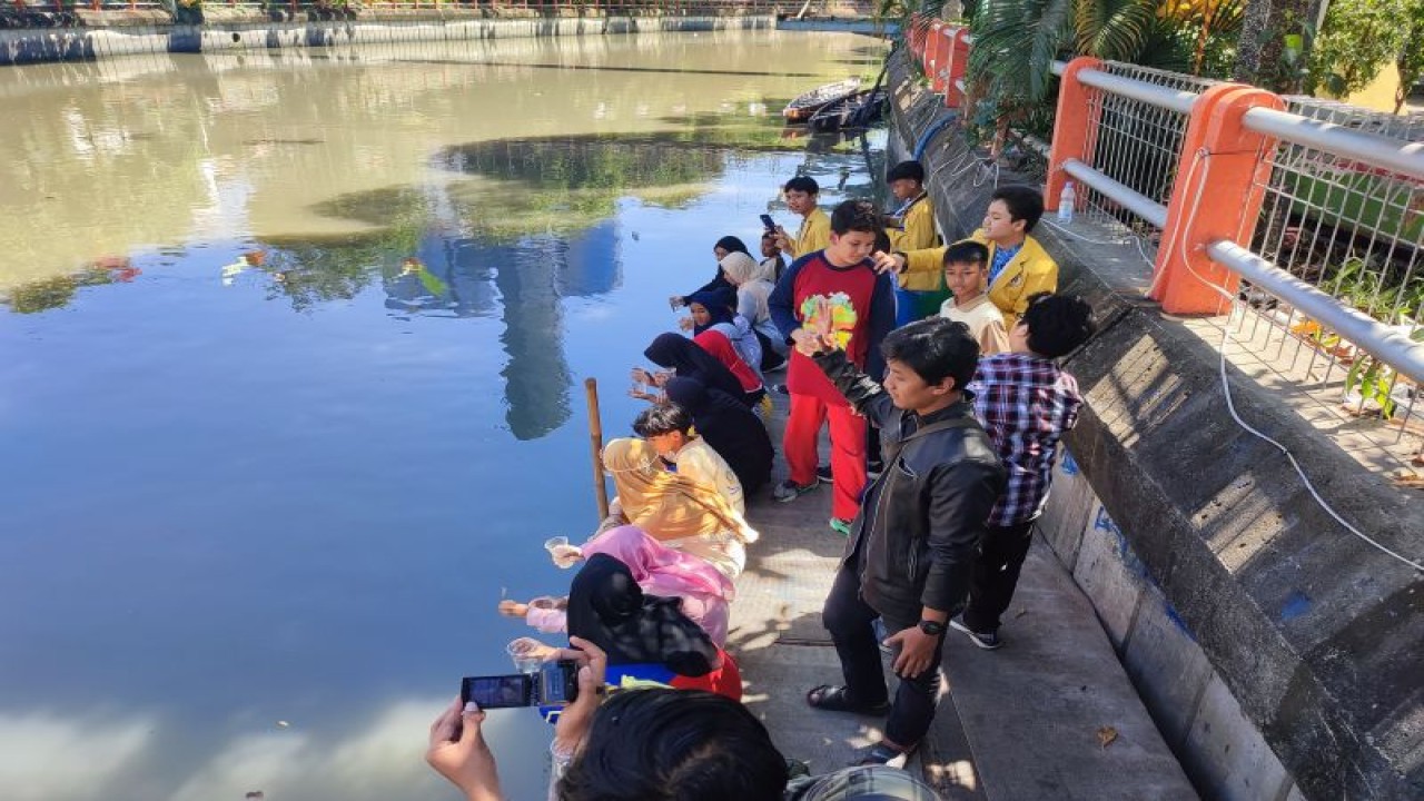 Siswa SMP Muhammadiyah 2 Surabaya saat melepaskan ikan di Sungai Kalimas sebagai bagian MPLS di sekolah setempat, Kamis (20/7/2023). (ANTARA/Willi Irawan)