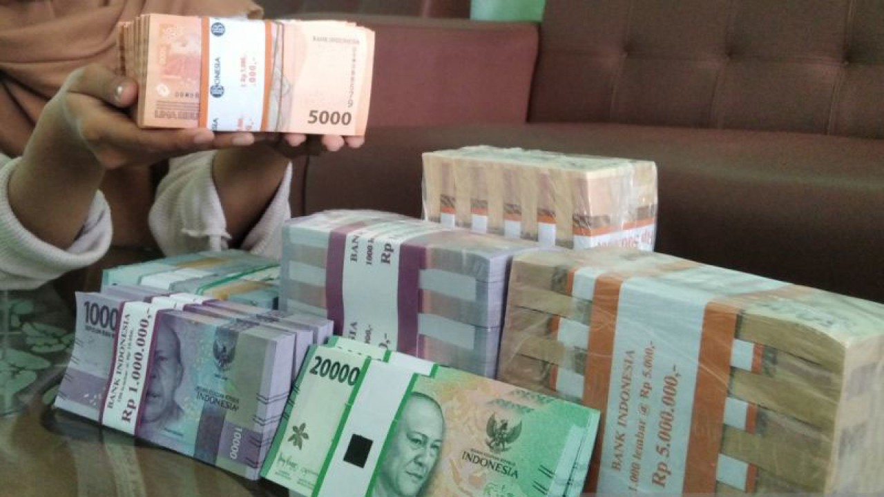 Seorang warga menunjukkan uang pecahan rupiah. ANTARA/Akhmad Nazaruddin Lathif