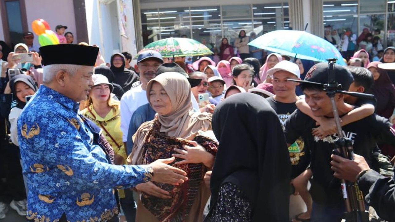 Bupati Malang M Sanusi (kiri) disambut warga pada saat menghadiri HUT ke-181 Desa Ngabab, di Kecamatan Pujon, Kabupaten Malang, Jawa Timur, Senin (17/7/2023). (ANTARA/HO-Prokopim Setdakab Malang)