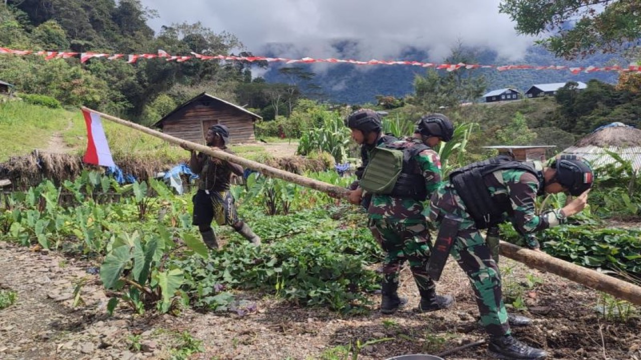 Satuan Tugas (Satgas) Yonif RK 115/ML bersama warga saat memasang bendera Merah Putih di Kampung Tirineri, Distrik Yambi, Kabupaten Puncak Jaya, Papua Tengah, Minggu (23/7). (ANTARA/HO-Humas Satgas Yonif RK 115/ML)