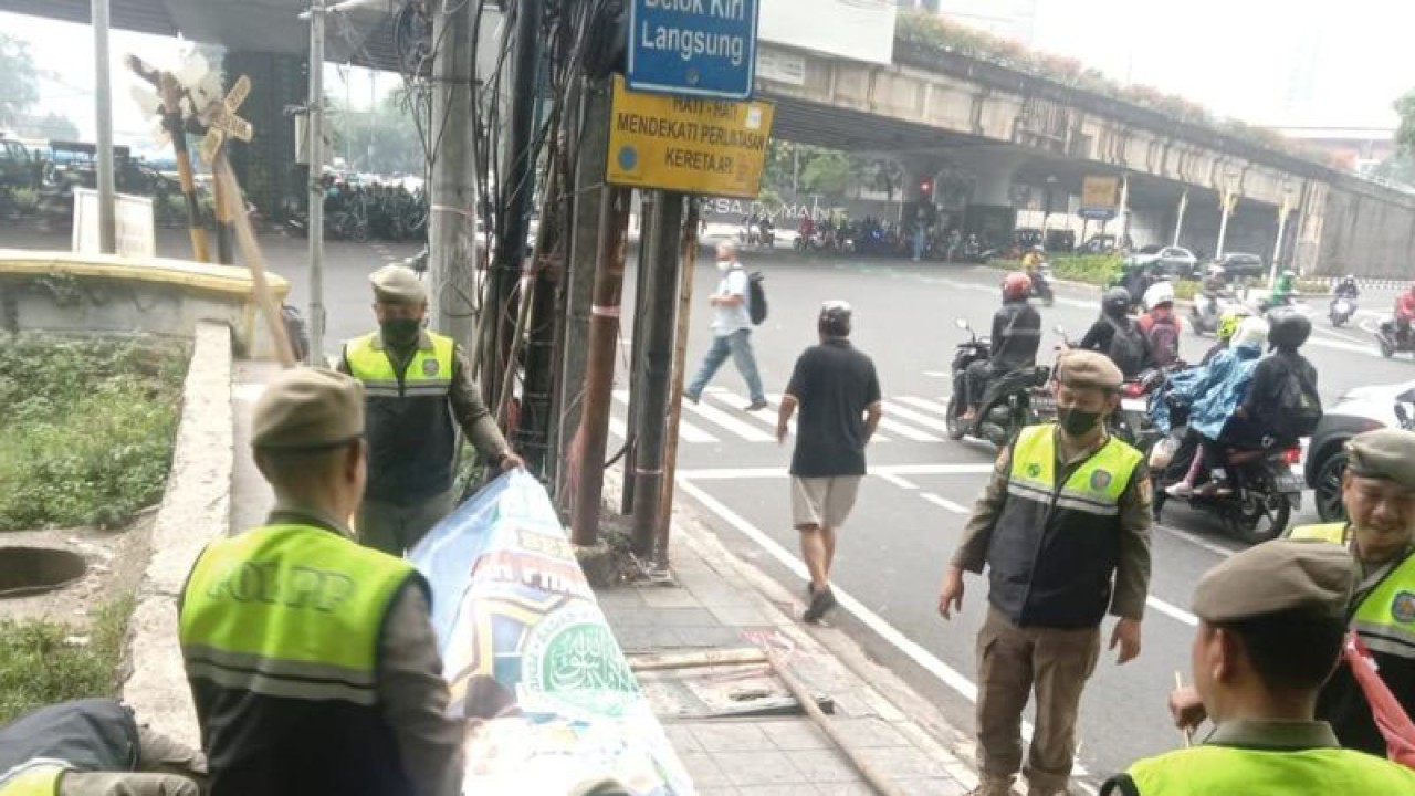 Satuan Polisi Pamong Praja (Satpol PP) DKI Jakarta menyita atribut berupa spanduk dan baliho partai politik yang tidak memiliki izin atau sudah habis masa penayangannya, Senin (24/7/2023). ANTARA/ HO-Satpol PP DKI Jakarta