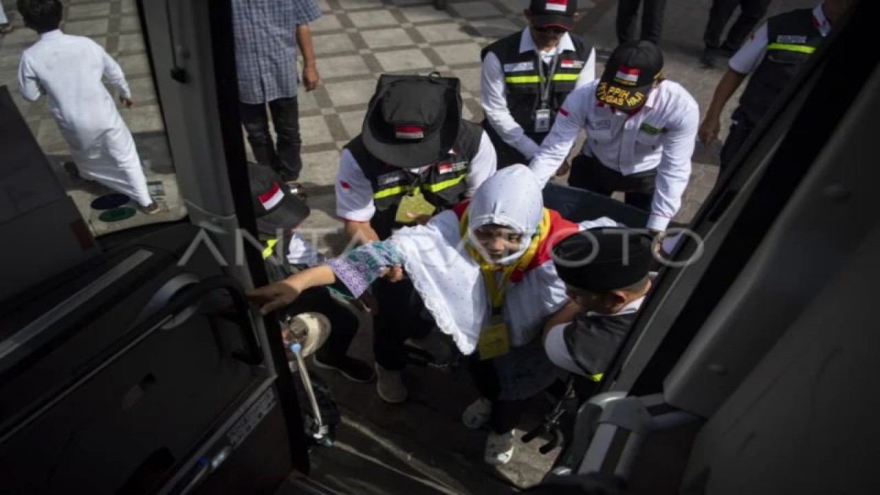 Petugas membantu seorang peserta ibadah haji kloter BTH 1 menaiki bus di Hotel 310 Syisyah, Mekah, Arab Saudi, Senin (3/7/2023). (ANTARA FOTO/Wahyu Putro A/aww.)