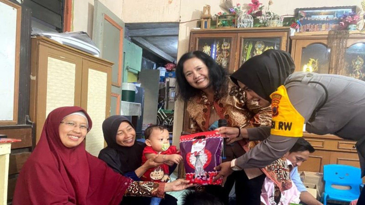 Seorang anggota Polwan Polresta Surakarta memberikan paket makannan bergizi kepada anak dalam acara bakti kesehatan cegah stunting, di Paud Menur 18 Kelurahan/Kecamatan Jebres Kota Solo, Kamis (27/7/2023). ANTARA/Bambang Dwi Marwoto.