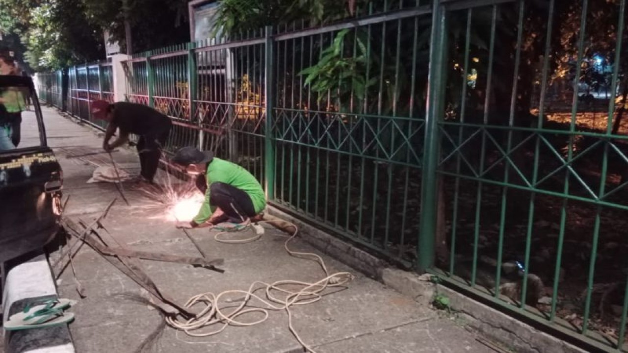 Petugas Suku Dinas Pertamanan dan Kehutanan (Tamhut) Jakarta Timur memperbaiki pagar yang berlubang di Hutan Kota, Cawang, Jakarta Timur, Rabu (26/7/2023). Perbaikan pagar hutan kota itu untuk mengantisipasi terjadinya tindakan asusila yang diduga dilakukan oleh kelompok lesbian, gay, biseksual dan transgender (LGBT). ANTARA/HO-Sudin Tamhut Jaktim