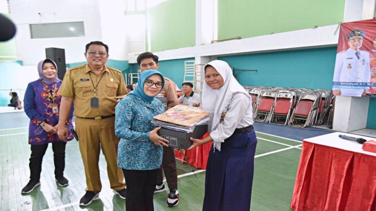 Ketua Tim Penggerak Pemberdayaan Kesejahteraan Keluarga (TP PKK) Surabaya Rini Indriyani saat menyerahkan seragam dan sepatu sekolah kepada sejumlah perwakilan pelajar di Gelanggang Remaja, Kota Surabaya, Jawa Timur, Selasa (25/7/2023). ANTARA/HO-Diskominfo Surabaya