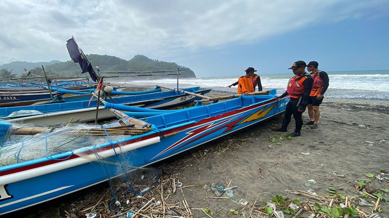 Tim Basarnas Cilacap mengecek kondisi perahu katir "Tunggal Asih" yang berhasil ditarik ke daratan setelah terbalik akibat dihantam gelombang di pantai sekitar TPI Pasir, Kabupaten Kebumen, Jateng, Senin (10/7/2023) pagi, sehingga mengakibatkan seorang nelayan hilang. FOTO ANTARA/HO-Basarnas Cilacap