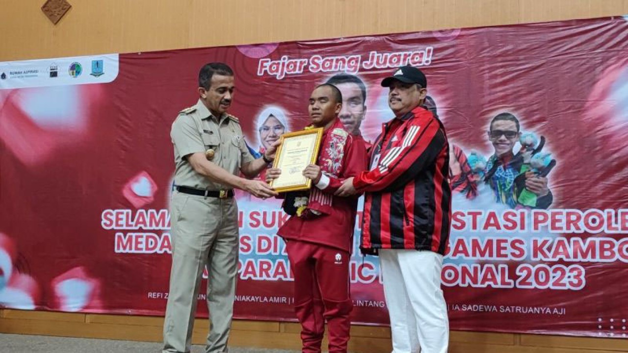 Wali Kota Administrasi Jakarta Timur Muhammad Anwar saat memberikan piagam penghargaan dan uang tunai sebesar Rp 25 juta kepada atlet renang penyandang disabilitas, Fajar Tri Hadi (21) sebagai peraih medali emas ASEAN Para Games Kamboja 2023 di Kantor Wali Kota Jaktim, Cakung, Senin (10/7/2023). ANTARA/Syaiful Hakim