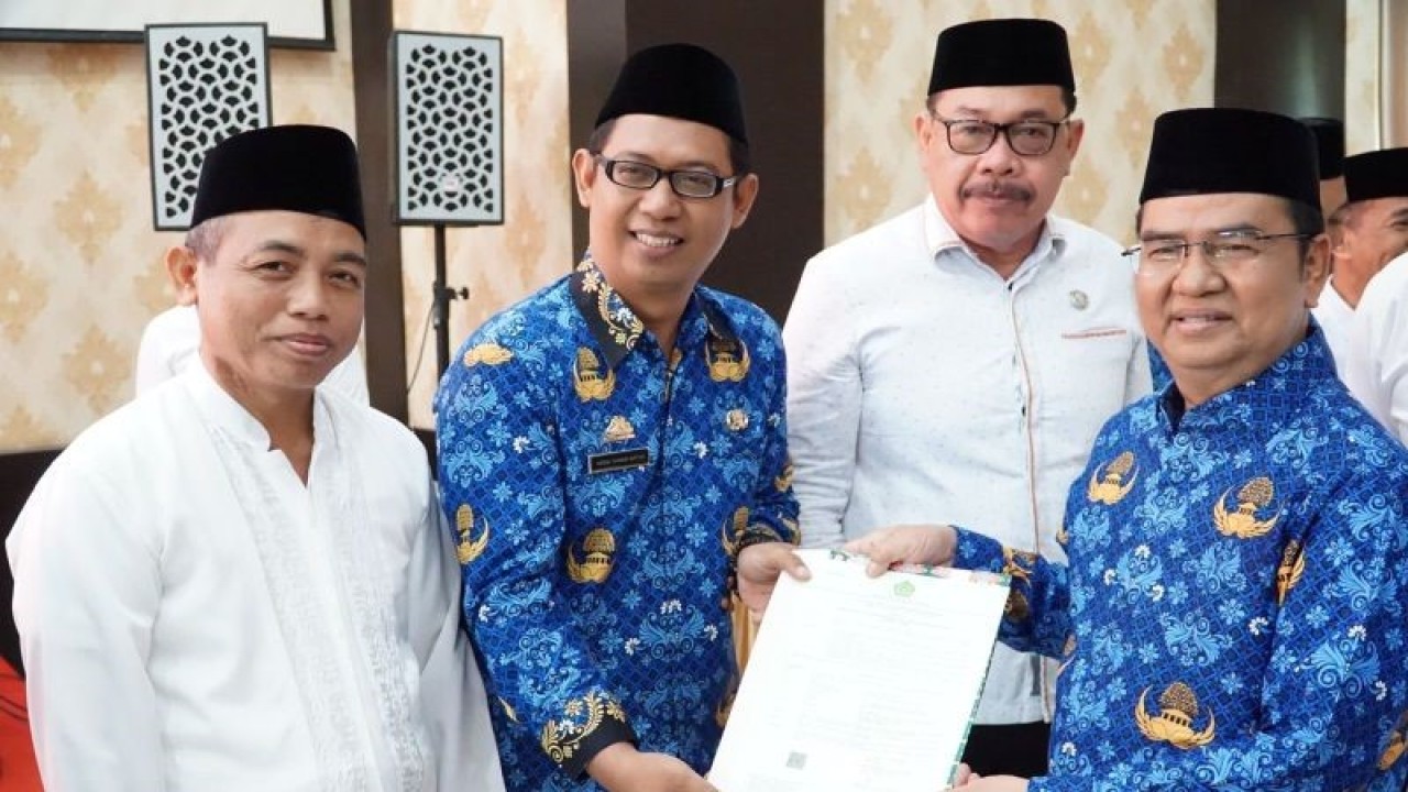 Kepala Kanwil Kemenag Sulsel Khaeroni (kanan) saat menyerahkan SK pengangkatan sebagai Pegawai Pemerintah dengan Perjanjian Kerja (PPPK) Kementerian Agama di Makassar, Rabu (16/8/2023). FOTO ANTARA/HO/Kemenag Sulsel