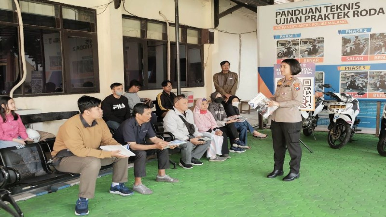 Kasat Lantas Polres Malang AKP Agnis Juwita (kanan) membagikan buku panduan kepada calon pemohon Surat Izin Mengemudi (SIM) di Satpas Karanglo Singosari, Kabupaten Malang, Jawa Timur, Kamis (10/8/2023). ANTARA/HO-Humas Polres Malang.