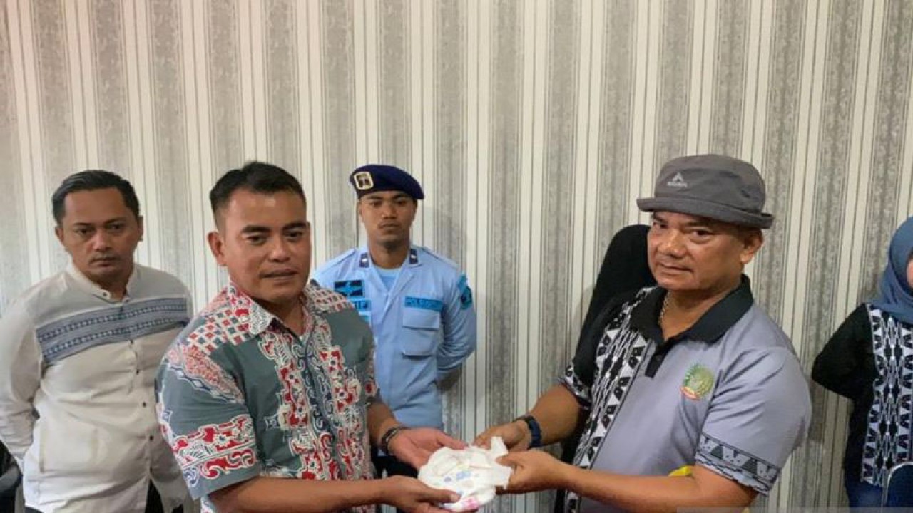 Kasat Resnarkoba Polresta Kendari AKP Hamka (kiri) saat menerima barang bukti sabu-sabu dari Kepala Lapas Kelas II A Kendari Tapianus Antonio Barus (kanan). Antara/La Ode Muh Deden Saputra.