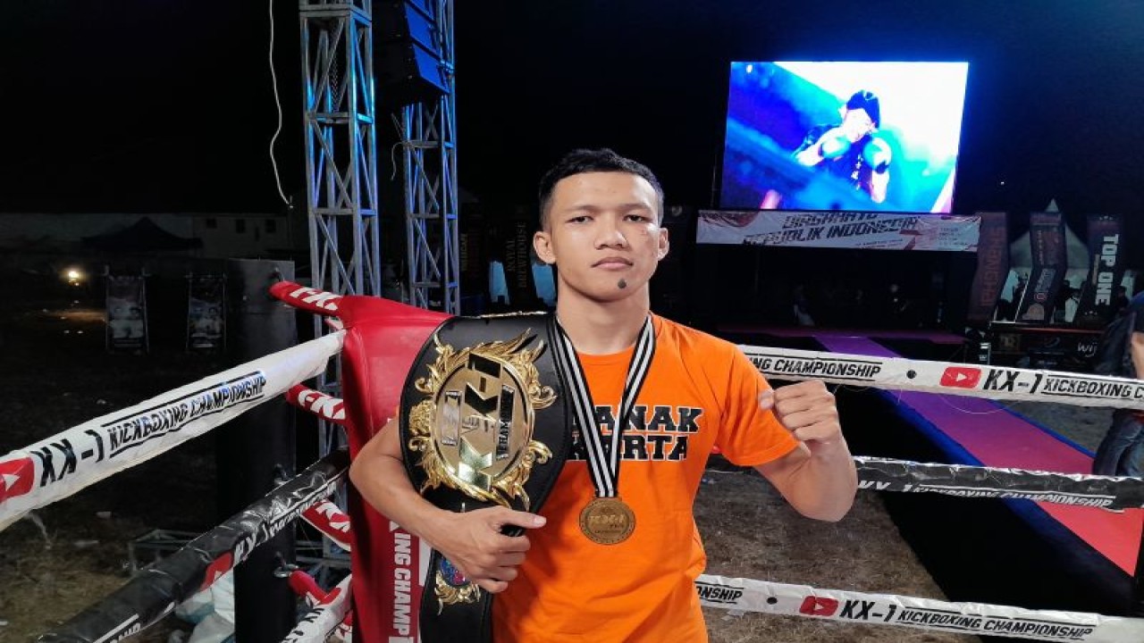 Atlet kick boxing Kamil Bagastrianto memamerkan sabuk juara nasional  KX-1 Kickboxing Championships series sembilan kelas 57 kg yang berlangsung di  Lapangan Garuda, Bantarkawung, Brebes, Jawa Tengah, Sabtu (19/8/2023). (ANTARA/FAJAR SATRIYO)