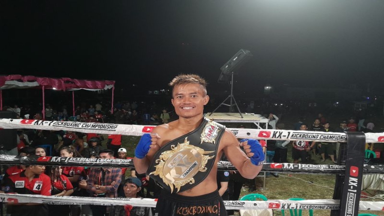 Atlet Kickboxing Alin Anggrianto memamerkan sabuk juara nasional KX-1 Kickboxing Championships Series 9 kelas 48 kg yang berlangsung di Lapangan Garuda, Bantarkawung, Brebes, Jawa Tengah, Minggu (20/8/2023). (ANTARA/FAJAR SATRIYO)