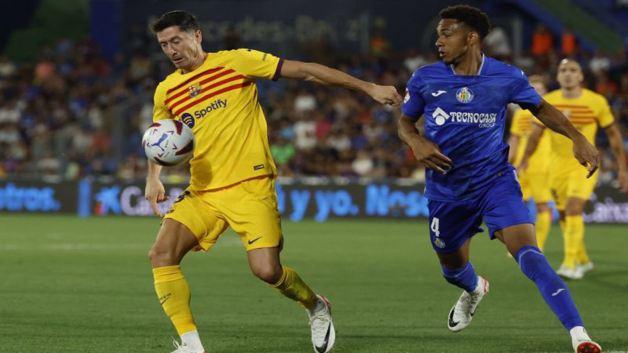 Penyerang Barcelona Robert Lewandowski (kiri) berduel memperebutkan bola dengan bek Getafe Gaston Alvarez dalam pertandingan Liga Spanyol di Col. Alfonso Perez stadium pada 14 Agustu 2023. ANTARA/AFP/JAVIER SORIANO